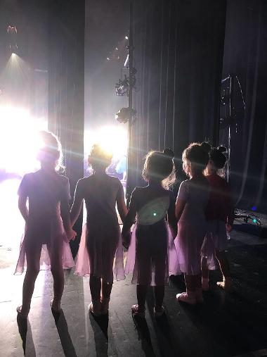 Children on stage with their backs to the camera
