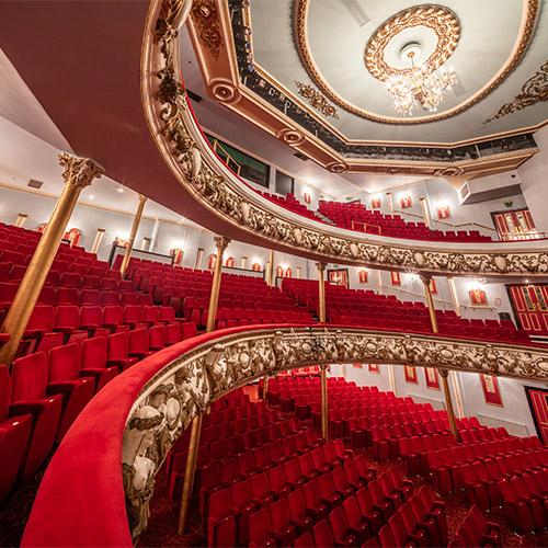 Detail of the inside of the auditorium, red seats, gold facade.