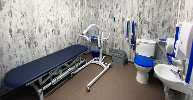 Accessible changing room with toilet, sink, bed and hoist